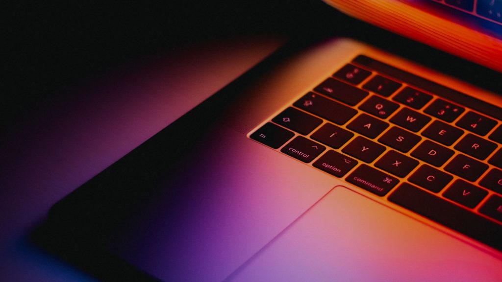 A picture of a laptop keyboard with the colours from the display reflecting onto it.